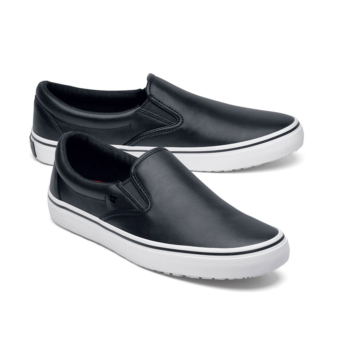 The Merlin Slip On Black and White from Shoes For Crews are slip-on trainers that are slip-resistant, lightweight, easy to clean and water-resistant, pair seen from the right side, emphasised on the tip of the right shoe.
