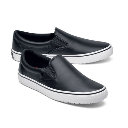 The Merlin Slip On Black and White from Shoes For Crews are slip-on trainers that are slip-resistant, lightweight, easy to clean and water-resistant, pair seen from the right side, emphasised on the tip of the right shoe.